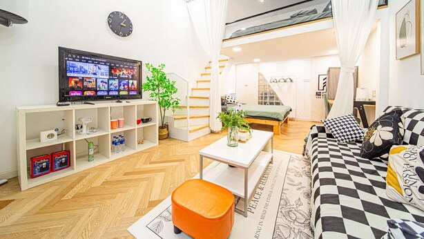 A modern living room with a television, a sofa, a coffee table, and a bookshelf. - Tonight Homestay South Shanxi Road Shanghai Ledu Building (SHANGHAI)