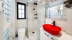 A modern bathroom with a glass-enclosed shower, a white toilet, and a red sink. - Tonight Homestay South Shanxi Road Shanghai Ledu Building (SHANGHAI)