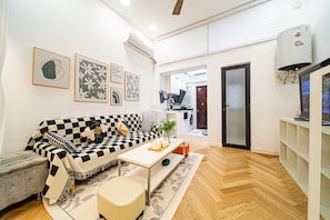A modern living room with a checkered sofa, a coffee table, and a TV stand.