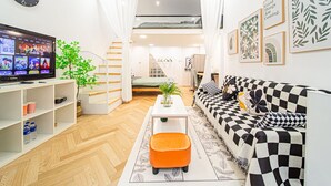A modern living room with a sofa, ottoman, and a flat-screen TV. - Tonight Homestay South Shanxi Road Shanghai Ledu Building (SHANGHAI)