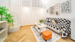 A modern living room with a checkered sofa, a coffee table, and a potted plant. - Tonight Homestay South Shanxi Road Shanghai Ledu Building (SHANGHAI)