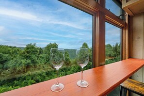 Two wine glasses on a wooden ledge with a view of a green landscape through a window. - 2 King Suites*Close to Gatlinburg-3 mile drive! (Gatlinburg)