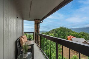 En balkon med udsigt over et skovlandskab.