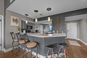 A modern kitchen with a central island, bar stools, pendant lighting, and a dining area with chairs. - 2 King Suites*Close to Gatlinburg-3 mile drive! (Gatlinburg)