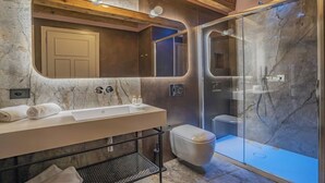 A modern bathroom with a marble sink, a toilet, and a glass-enclosed shower. - ELEGANT CORTE RUBBI 2-BEDROOM RETREAT STEPS FROM ST. MARK'S SQUARE (Venezia)