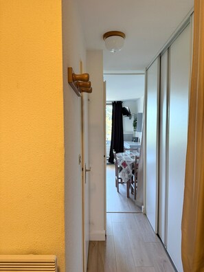 A narrow hallway leading to a dining area with a table and chairs. - Studio for 4 – Résidence Les Marmottes – 1750 Chamrousse (Chamrousse)