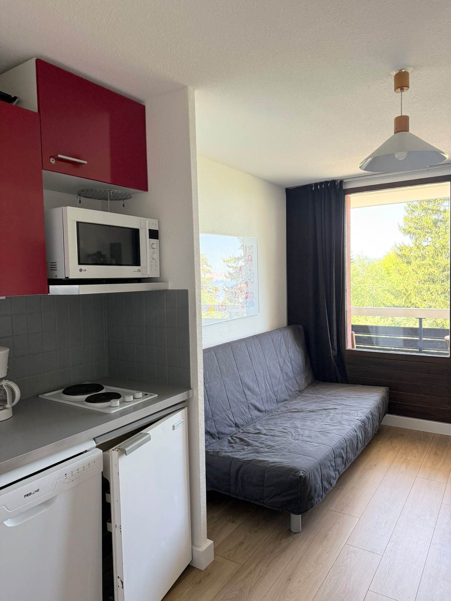 A compact kitchenette with a microwave, a small refrigerator, and a coffee maker.