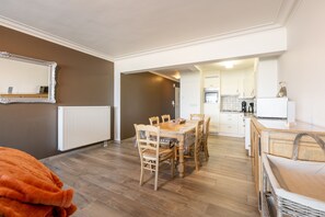 Une cuisine moderne avec des meubles blancs, un four encastré et une machine à café.