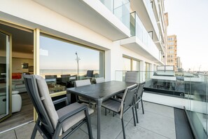 Ein moderner Essbereich im Freien mit Tisch und Stühlen, mit Blick auf eine Skyline.