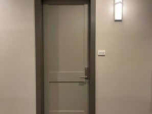 Eine geschlossene Tür mit einer Nummernschild '402' und einer Leuchte darüber.