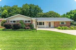 A single-story house with a brick facade, a front porch, and a well-maintained lawn. - Home in the heart of Fort Walton Beach with private pool, minutes fromthe beach (Fort Walton Beach)