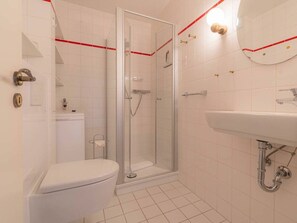 Ein Badezimmer mit Toilette, einer Duschkabine und einem Waschbecken.