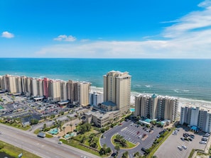 Un hotel moderno con vista sull'oceano, parcheggio e piscina.
