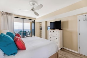 Ein Hotelzimmer mit Bett, Fernseher, Kleiderschrank und einem Balkon mit Aussicht.