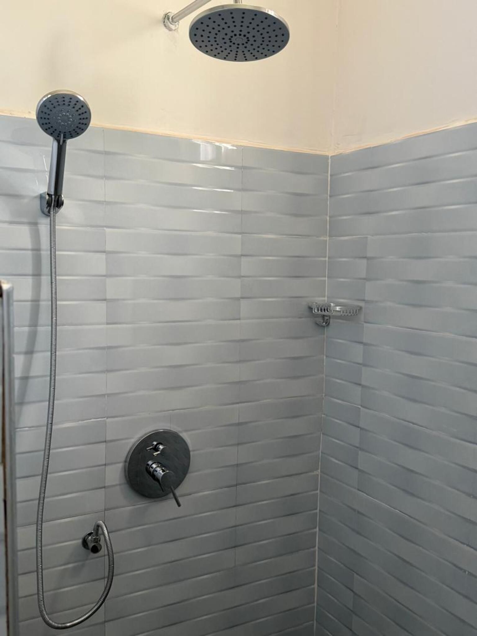 Ducha con cabezal de ducha de mano y grifería empotrada.