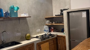 Una cocina moderna con refrigerador de acero inoxidable, armarios de madera y salpicadero de azulejos.