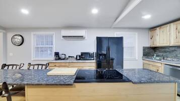 A modern kitchen with a central island, built-in appliances, and wooden cabinetry.