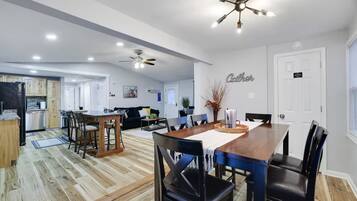 Un salón amplio con mesa de comedor, sillas, sofá y ventilador de techo.