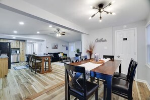 Un salón amplio con mesa de comedor, sillas, sofá y ventilador de techo.