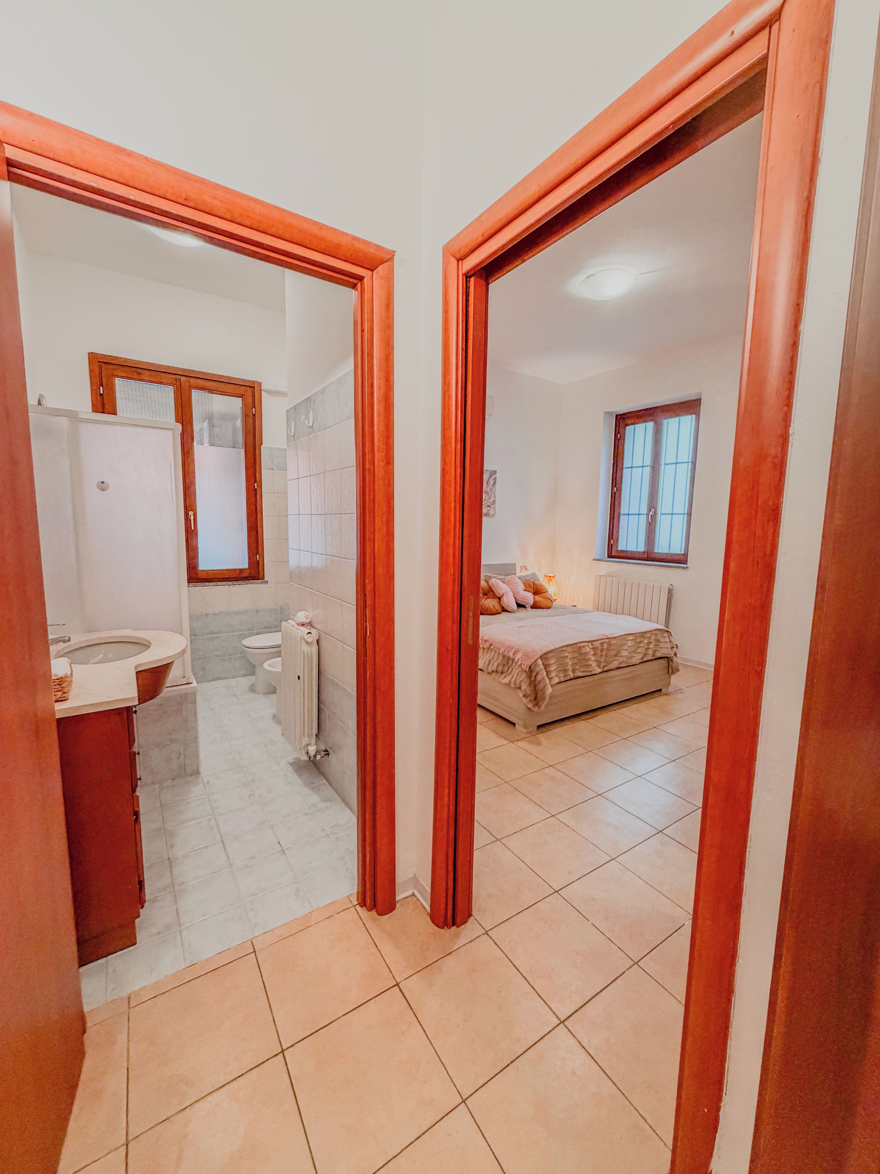 Una camera da letto con un letto, una finestra e un bagno con il water e un lavandino.