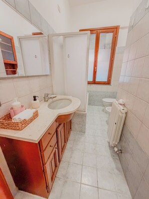 Ein Badezimmer mit Waschbecken, Toilette und Spiegel.