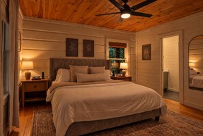 Ein Schlafzimmer mit Bett, Nachttischen, Deckenventilator und Fenster.