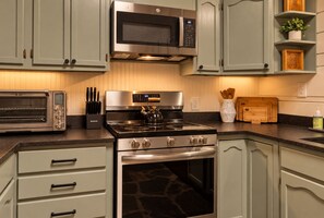 A kitchen with a built-in microwave, toaster oven, and stove.