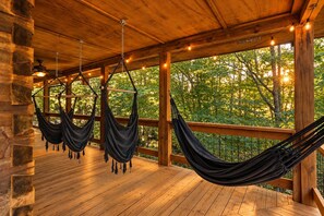 A wooden deck with hammocks and a view of trees. - Luxe Cozy Creekfront Cottage | Bailey Creek Cabin (Marietta)