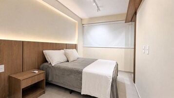 Una camera da letto moderna con un letto, un comodino e illuminazione integrata.