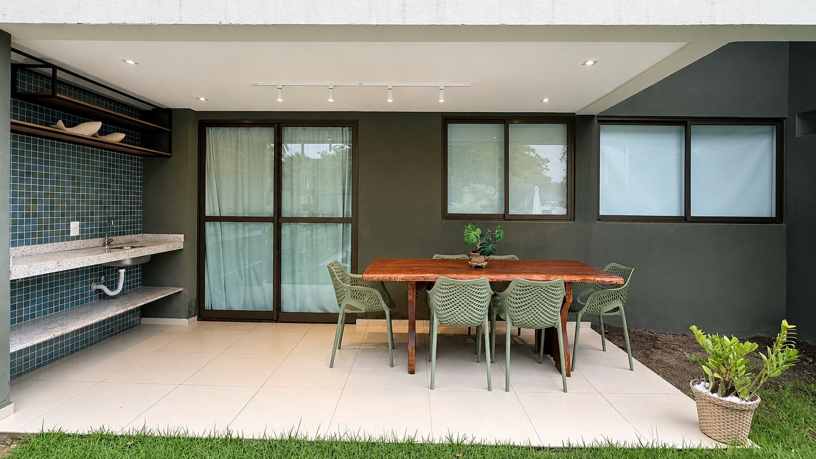 Uma sala de jantar com mesa e cadeiras de madeira, um vaso de planta e uma janela com vista.