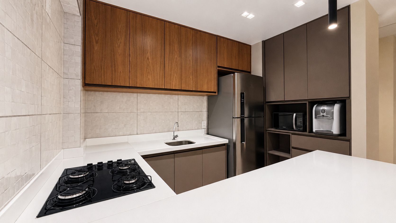 A modern kitchen with a gas stove, stainless steel refrigerator, and built-in microwave.