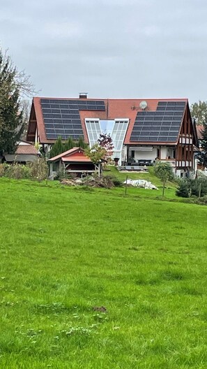 Un edifici gran amb teulada inclinada i panells solars.
