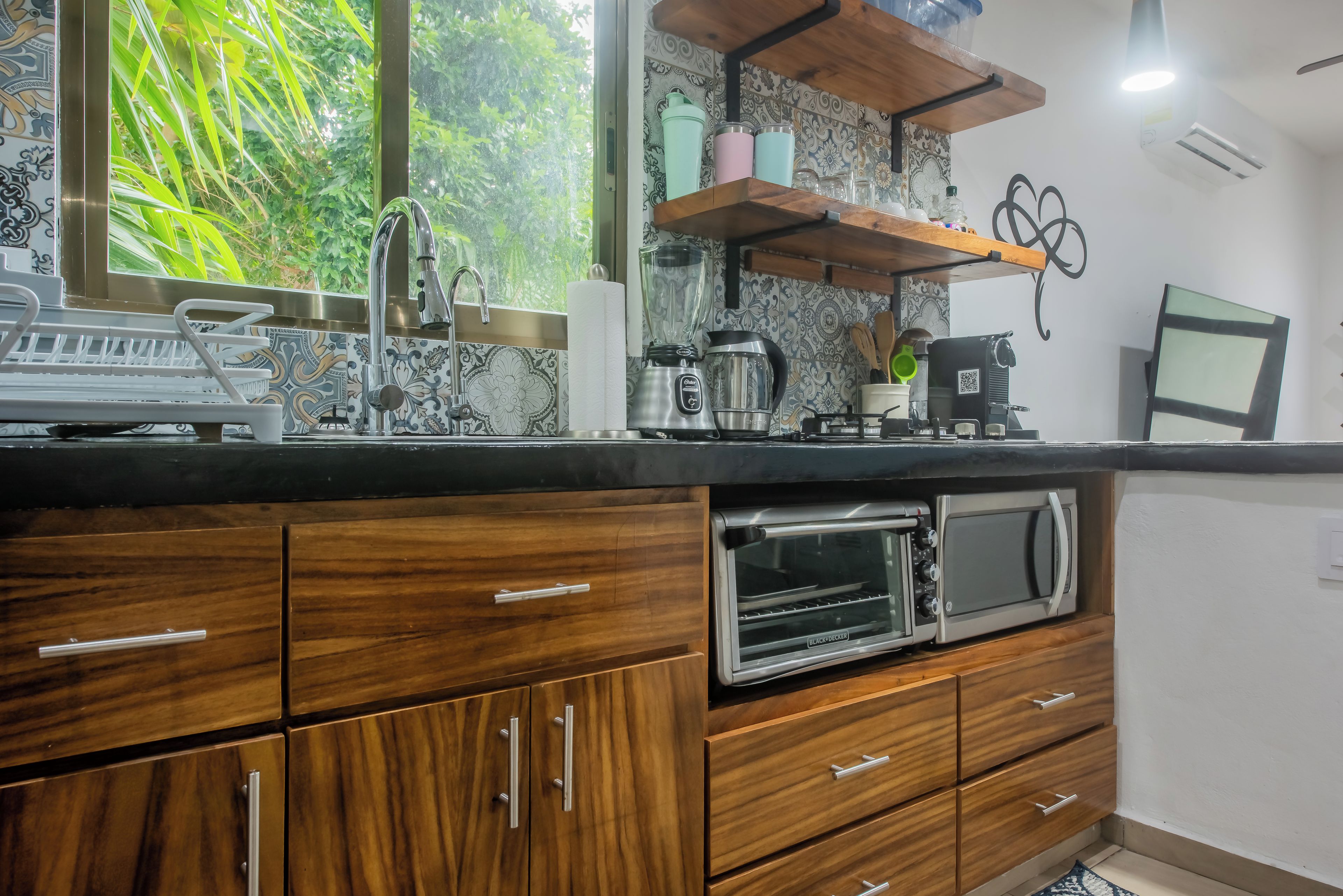Una cocina equipada con horno, cafetera y licuadora.
