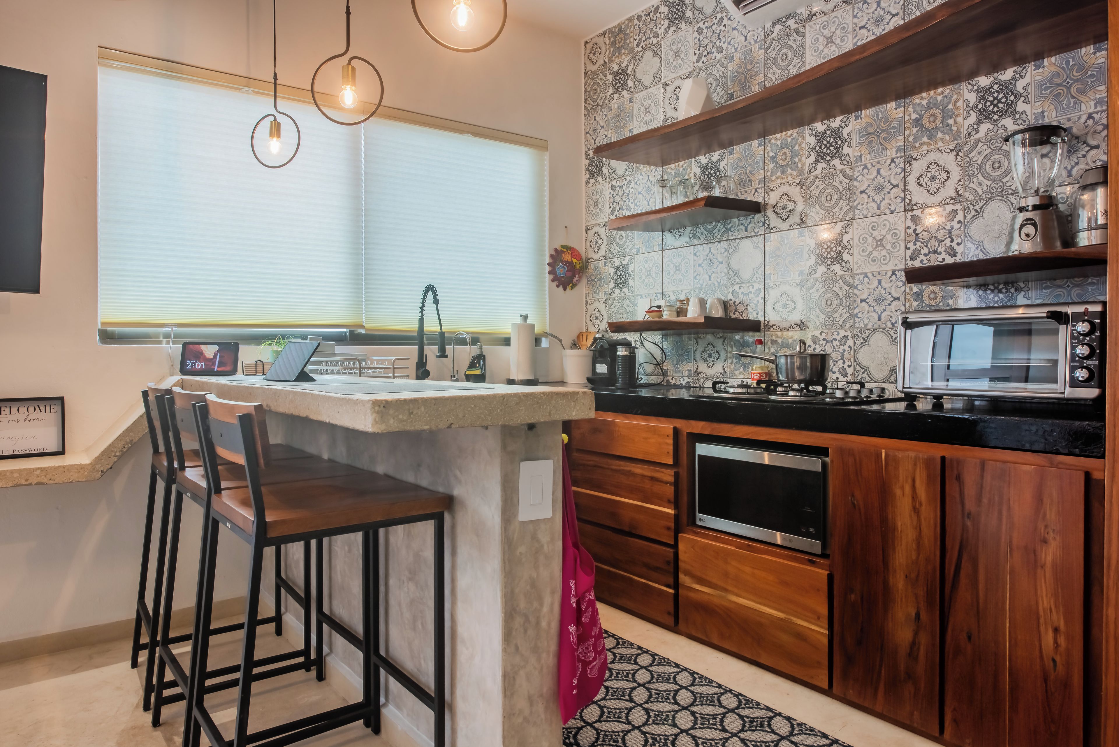 Una cocina moderna con barra, microondas y cafetera.