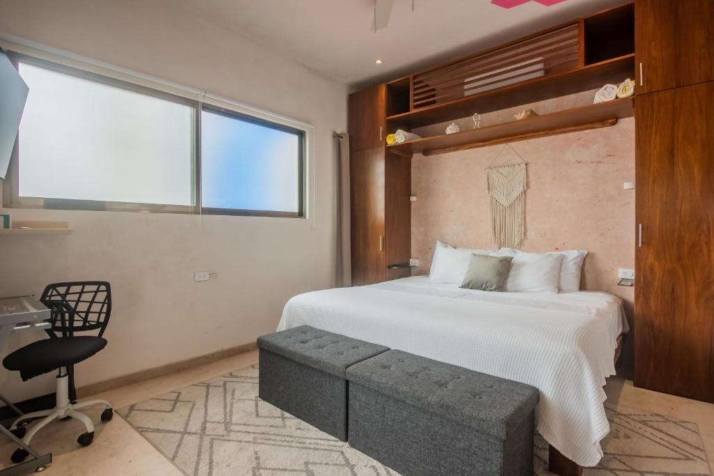 Un dormitorio con cama, escritorio y silla.