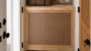 Een houten bank met een gevlochten mand en een hangplant.