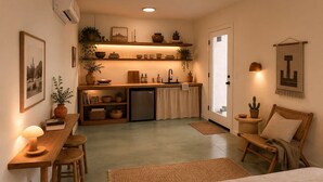 A compact living space with a kitchenette, a dining area, and a seating area with a chair and a table. - La Villa Uno • The Otherside • BBNP + Terlingua (Terlingua)