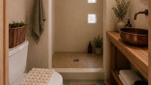 A bathroom with a white toilet, a wooden vanity with a copper basin, a small plant, and a mirror. - La Villa Uno • The Otherside • BBNP + Terlingua (Terlingua)