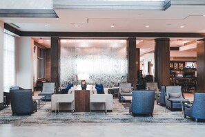 Eine Lobby mit einer Sitzecke, einer Bar und einer großen dekorativen Wandgestaltung.