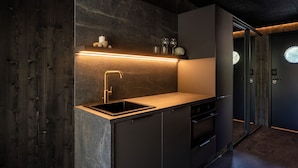 Una cocina moderna con un lavamanos integrado, un grifo de acero inoxidable y una encimera.
