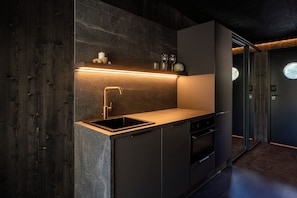 A modern kitchen with a built-in sink, a stainless steel faucet, and a countertop. - Aurora sea resort  (Kuivaniemi)