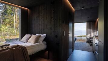 A modern interior with a bed, wooden walls, and a view of the outdoors.