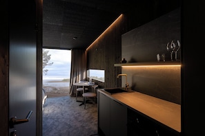 Una cocina moderna con estufa integrada, un lavamanos y una ventana con vistas a un paisaje natural.