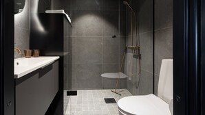 Un baño moderno con ducha, inodoro y lavabo.