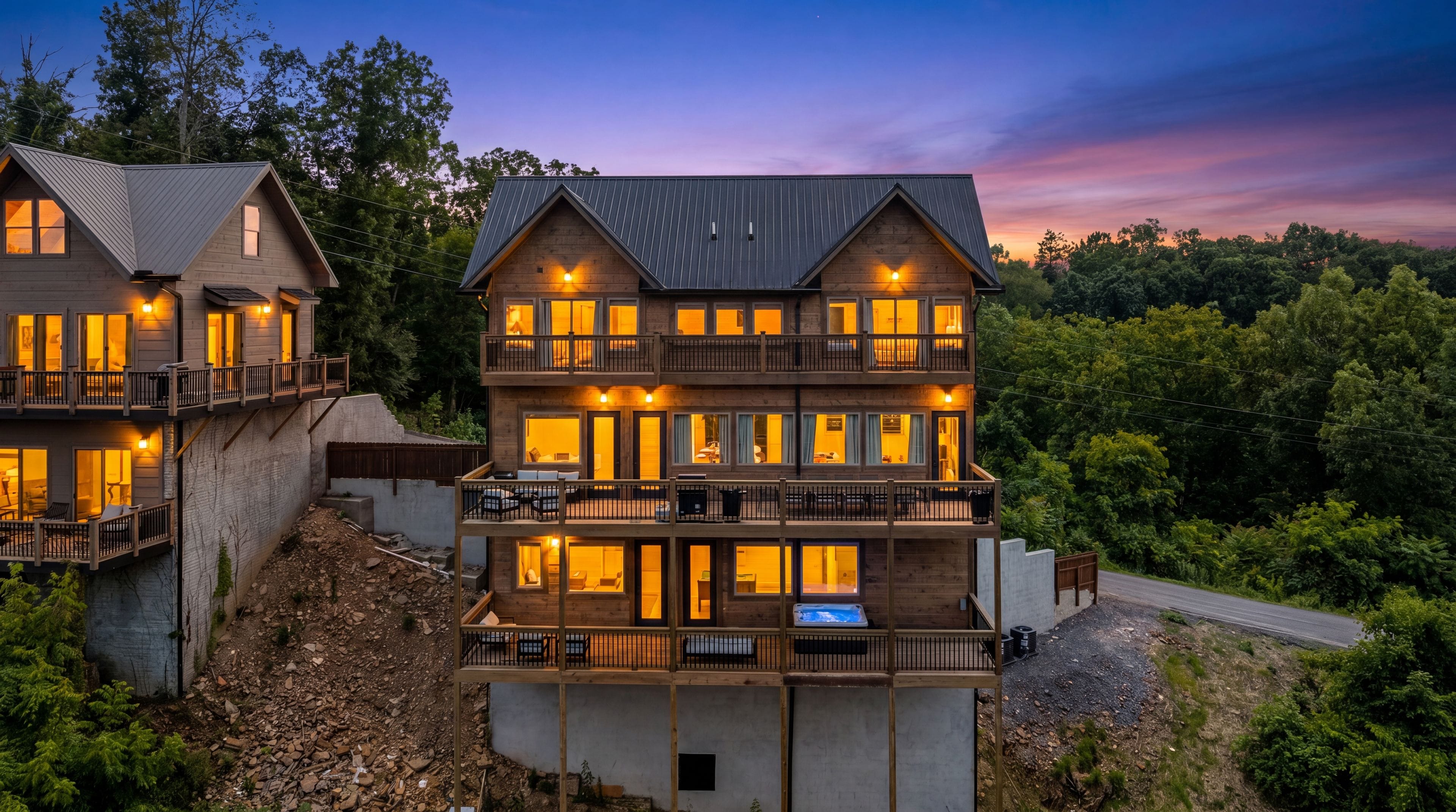 A multi-story wooden building with balconies, large windows, and a view of the surrounding forest.