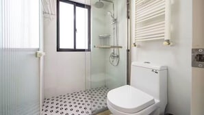 Ein Badezimmer mit Duschkabine, Toilette und Handtuchheizkörper.