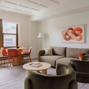 A modern living room with a sofa, chairs, a coffee table, and a painting on the wall. - Luxury Designer Apartment 1003|Gold Coast/Old Town (Chicago)