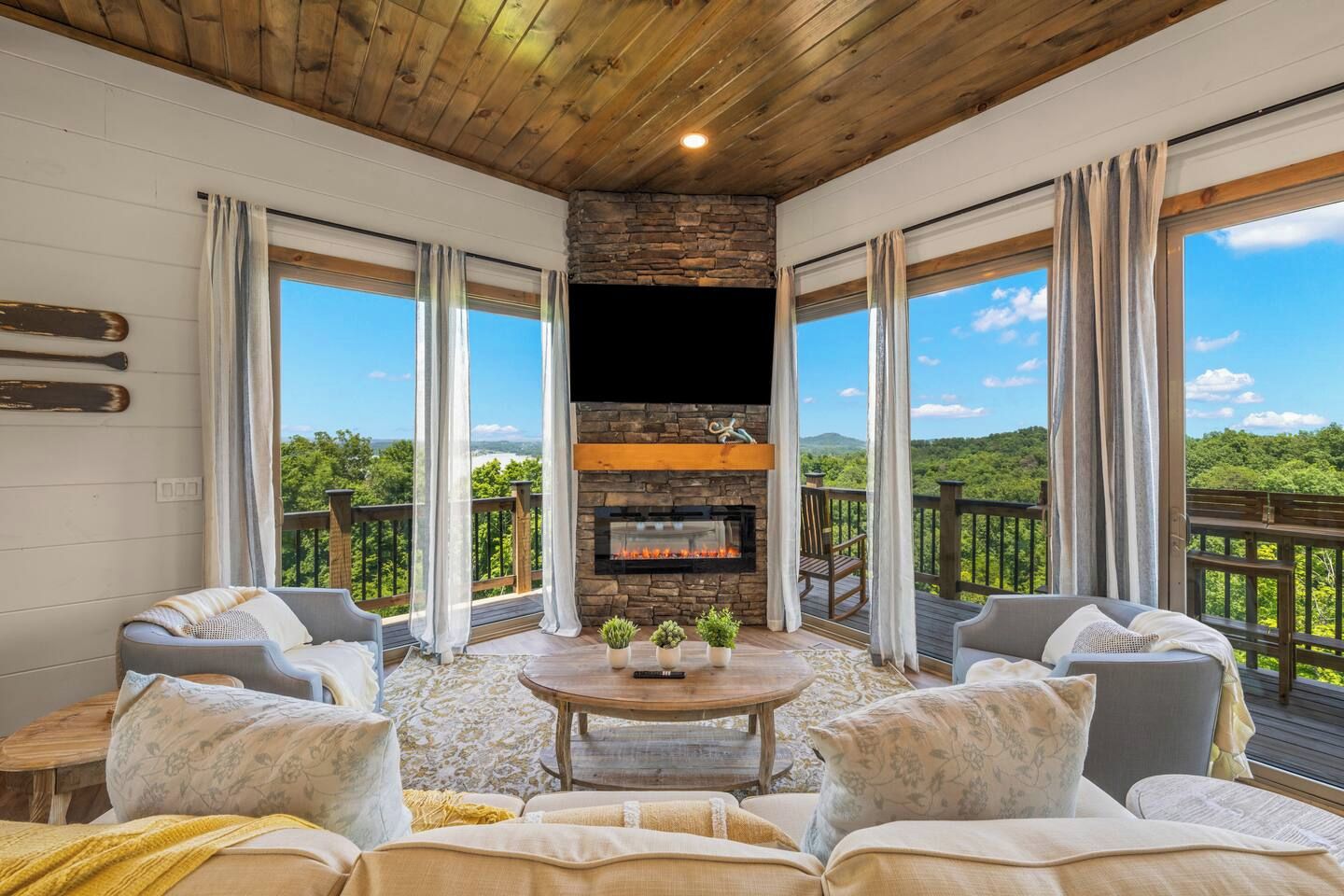 A cozy living room with a fireplace, comfortable seating, and a scenic outdoor view.
