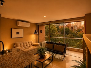 Uma sala de estar moderna com sofá, mesa de centro e área de jantar com bancada de granito.