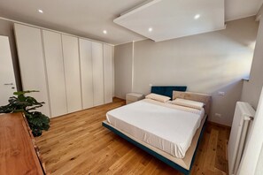Una camera da letto con un letto, comodini, un armadio e un termosifone.